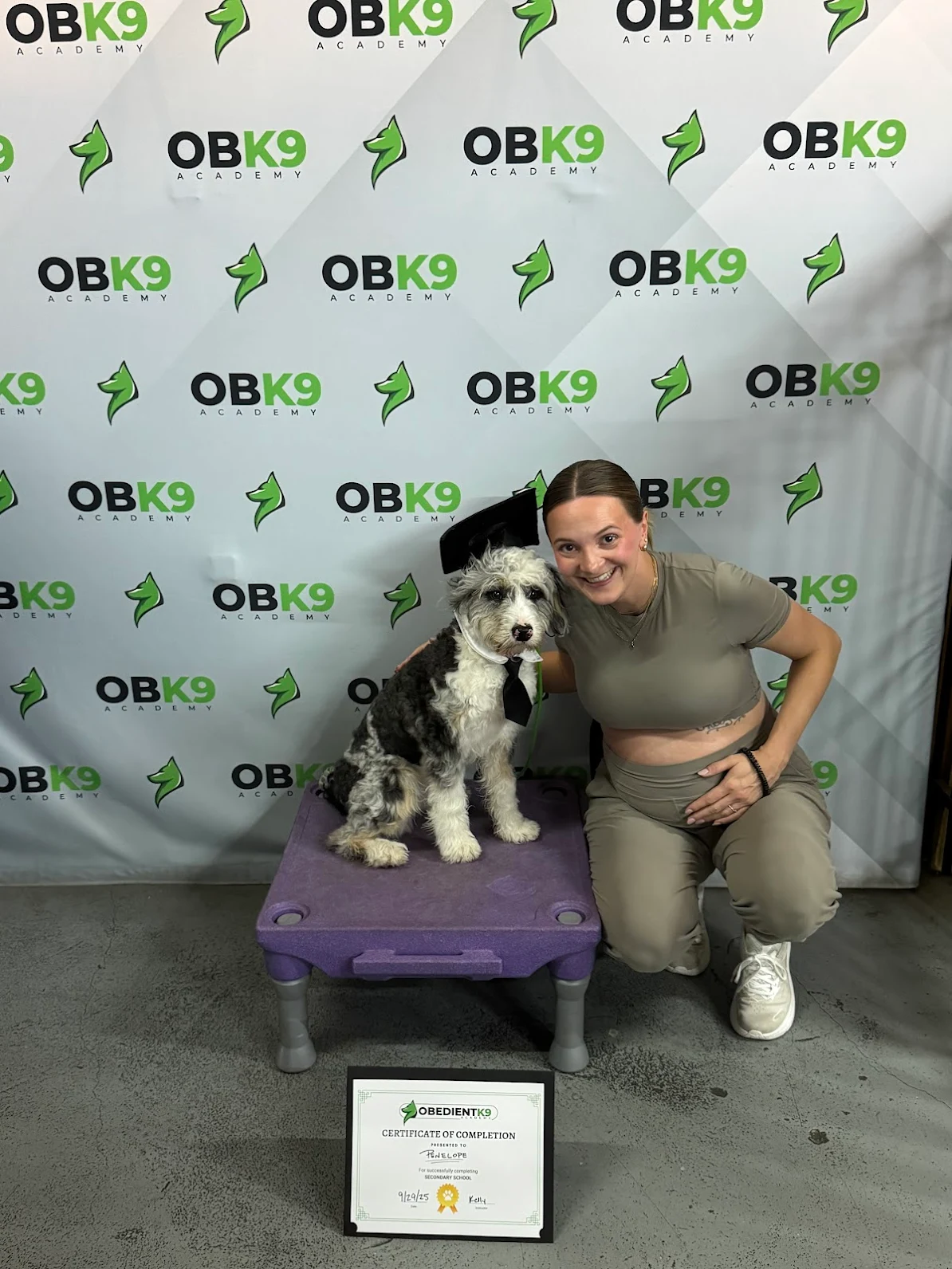 Brenda with Penelope the Bernedoodle at her Obedient K9 graduation